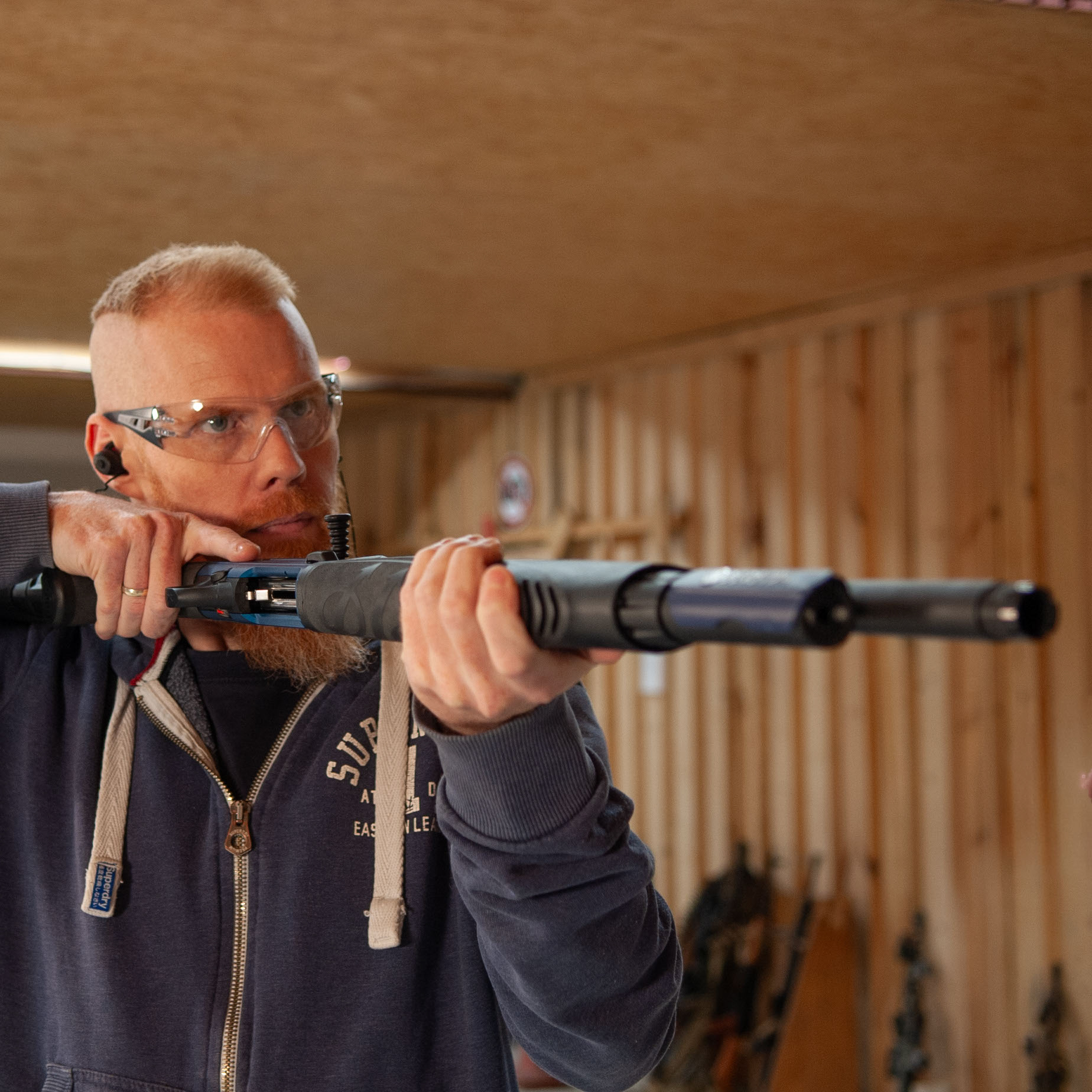 Sportschütze steht im Anschlag mit einer Schrotflinte