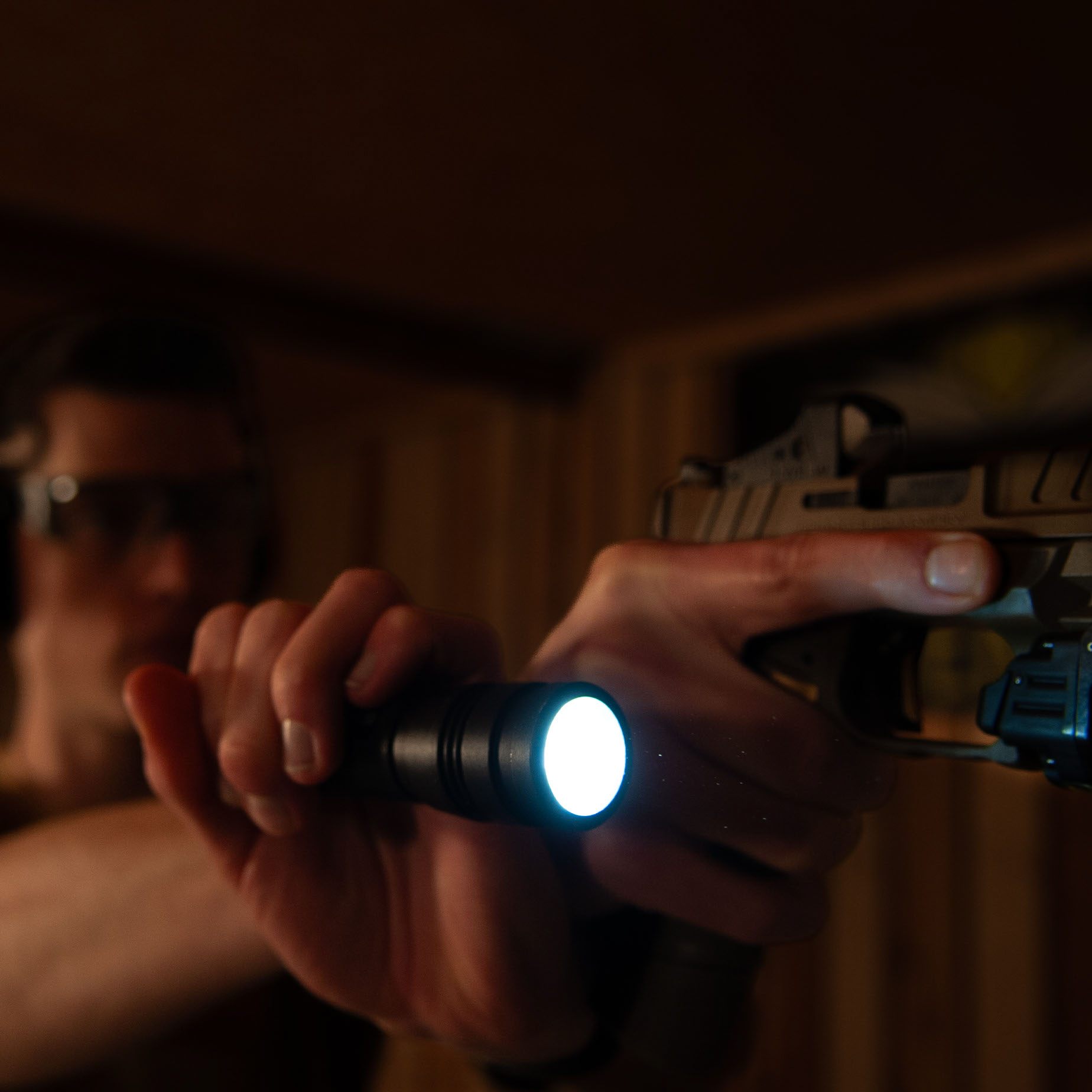 Sportschütze leuchtet mit seiner taktischen Taschenlampe auf das Ziel