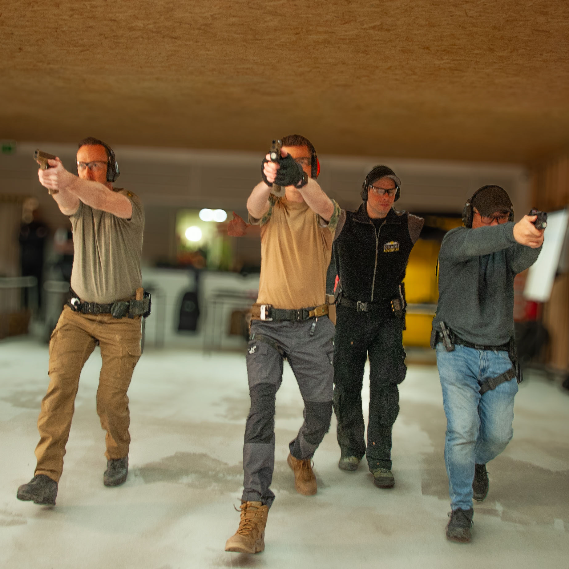 Drei Sportschützen schießen während des gehens. Geleitet von einem Schießtrainer