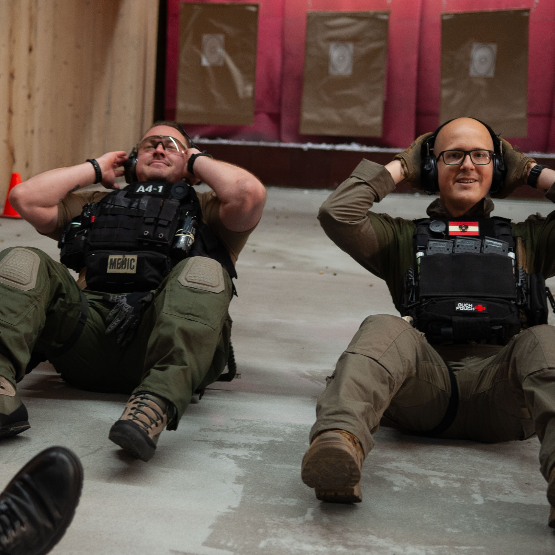 Zwei Sportschützen machen in militärischer Ausrüstung Sit-Ups